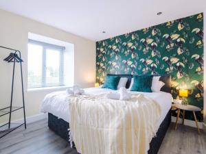 a bedroom with a large bed with a green wall at The Ecclesian Deluxe Apartments near Trafford Centre Eccles Train Station in Manchester