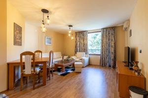 a living room with a table and a dining room at Golden Sands 1BD Summer Retreat by Flat Mаnаger in Golden Sands