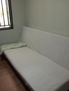 un letto bianco in una stanza con finestra di Nyakach Getaway Kisumu a Kap Sarok