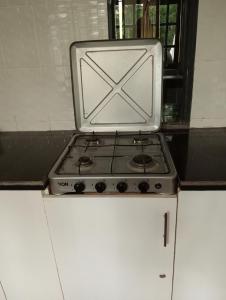 a stove top oven sitting on top of white cabinets at Nyakach Getaway Kisumu in Kap Sarok