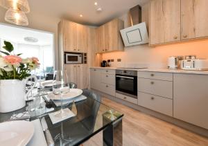a kitchen with a glass table and a dining room at Sealight in Pwllheli
