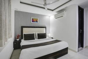 a white bedroom with a bed and a window at Super OYO Hotel Mannat Near Lotus Temple in New Delhi