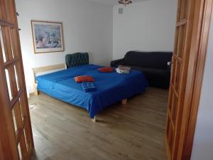 um quarto com uma cama azul e um sofá em Villa venere e spa em Palermo