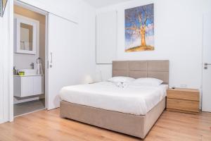 1 dormitorio blanco con 1 cama grande y baño en Venus Apartment, en Lárnaca