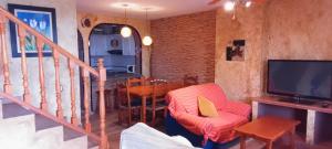 ein Wohnzimmer mit einem TV und einem Esszimmer in der Unterkunft Apartamento con varias piscinas, jardines y garaje en Costa Hispania in Gran Alacant
