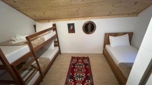 Kleines Zimmer mit 2 Etagenbetten und einem Teppich in der Unterkunft Te baca Qerim in Lekbibaj