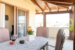 una sala da pranzo con tavolo e bicchieri da vino di Maria's Roof Garden a Heraklion