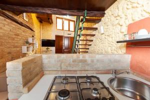 uma cozinha com um fogão e um lavatório em Loft Antica Cagliari em Cagliari