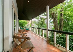 a porch with two chairs and a tree at Katamanda villa Sooksan in Kata Beach