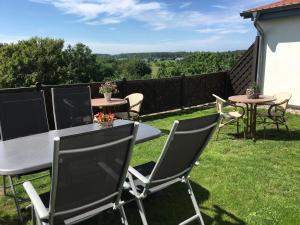 un patio con mesas y sillas en el césped en Ferienhaus Grawwert, en Polchow