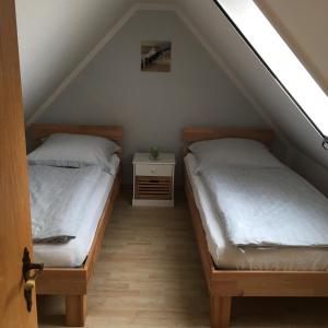 2 camas en una habitación con ático en Ferienhaus Grawwert, en Polchow