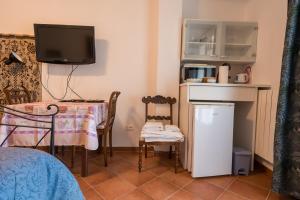 een kamer met een tafel en een televisie en een tafel en stoelen bij Tra Gli Ulivi in Pietra Ligure
