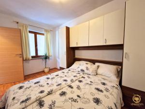 a bedroom with a bed with a floral bedspread at Apartment Saria Strunjan in Strunjan