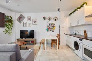 Una cocina y una sala de estar con un sofá y una mesa. en Apartamento Obispo centro Jerez de la Frontera, en Jerez de la Frontera