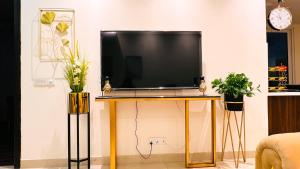 a television on a stand in a living room at Gold Crest Mall Luxury Apartments DHA Lahore in Lahore