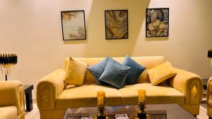 a living room with a couch with pillows on it at Gold Crest Mall Luxury Apartments DHA Lahore in Lahore