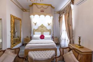 Un dormitorio con una cama grande con una almohada roja. en Suite Royale Maison de l'église du couvent, en Narbona