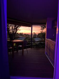 een kamer met een tafel en een balkon met een zonsondergang bij Ononui Airport Studio in Faaa