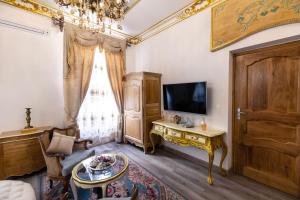 un salon avec une télévision et une table dans l'établissement Suite Royale Maison de l'église du couvent, à Narbonne