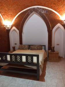 um quarto com uma cama numa parede de tijolos em Guesthouse Nut em Luxor