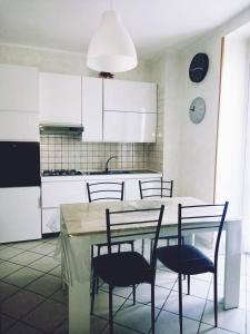 kuchnia ze stołem i krzesłami oraz kuchnia z białymi szafkami w obiekcie Pasubio House Intero appartamento w mieście Campobasso