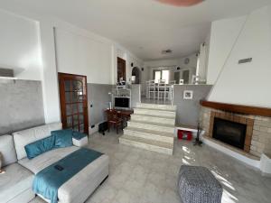 sala de estar con sofá y chimenea en Terra da Eira - Villa mit Pool Western Algarve, en Vila do Bispo