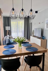 a dining room with a wooden table and chairs at Apartament Seaside Dune - Aleja Południowa 14A Dźwirzyno in Dźwirzyno