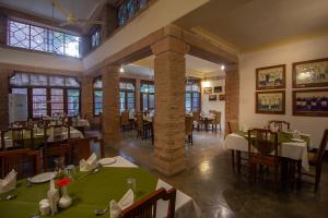 ein Restaurant mit Tischen und Stühlen in einem Zimmer in der Unterkunft Polo Heritage Hotel in Jodhpur