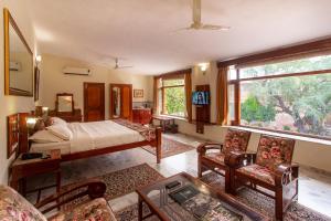 a bedroom with a bed and a living room at Polo Heritage Hotel in Jodhpur