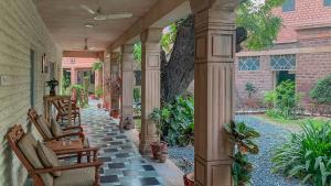 weranda z krzesłami i stołem oraz budynek w obiekcie Polo Heritage Hotel w mieście Dźodhpur