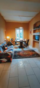 ein Wohnzimmer mit einem Sofa und einem Tisch mit Stühlen in der Unterkunft Residenza BiblioSosta in Ventimiglia