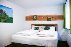 een slaapkamer met een bed met witte lakens en kussens bij Wildgrün Königs Lodge 17 in Pfronten