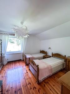 a bedroom with two beds and a large window at W Ogrodzie Dla Gości in Sasino