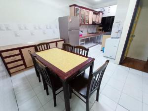 a kitchen with a table and chairs and a refrigerator at Kota 3BR Townhouse 5 Pax - TVBox/Mahjong/Jonker in Melaka