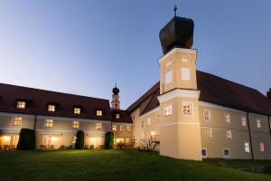 un gran edificio con una torre de reloj en el patio en Klosterhof St. Salvator en Bad Griesbach