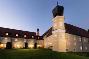 a large building with a clock tower in the yard at Klosterhof St. Salvator in Bad Griesbach