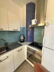 a kitchen with white cabinets and a stove top oven at La Casa di Anna, Mondello in Palermo