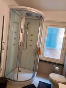baño con ducha, aseo y ventana en House1919 Via Valmara 14, en Brissago