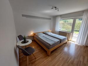 a bedroom with a bed and a table and a chair at Pension Mosella, Gästezimmer in Sankt Aldegund