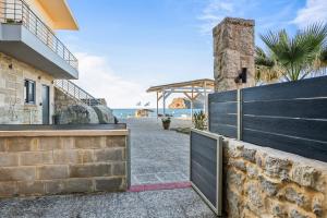 a gate to a house with the beach in the background at Celeste Junior Suite on the Beach in Nea Kydonia