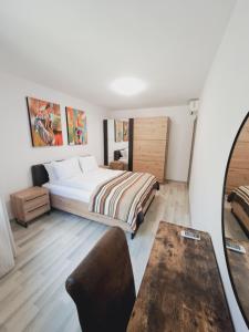 a bedroom with a bed and a table at Apartment Aphaya, complex Carpe Diem, Апартамент Афайя, комплекс Карпе Дием in Balchik