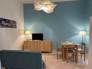 a living room with a table and a tv at Villa Bucchi in Lido di Spina