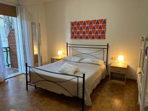 a bedroom with a bed and two lamps and a window at Villa Bucchi in Lido di Spina