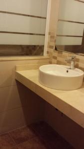 ein Badezimmer mit einem weißen Waschbecken und einem Spiegel in der Unterkunft Apartamento con varias piscinas, jardines y garaje en Costa Hispania in Gran Alacant