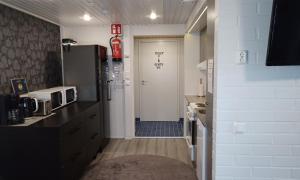 eine kleine Küche mit einer Tür, die auf einen Flur führt in der Unterkunft Kuukkeli Saariselkä Inn in Saariselkä