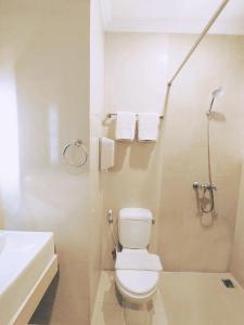 a white bathroom with a toilet and a sink at Pandanaran Prawirotaman Yogyakarta in Yogyakarta