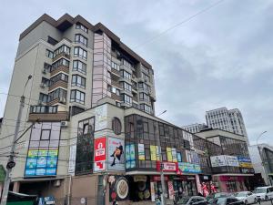 a tall building on a city street with cars at Чарівна квартира-студія на мансардному поверсі! in Ternopil