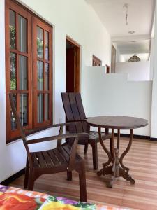 ein Esszimmer mit einem Tisch und 2 Stühlen in der Unterkunft Aroma Guest House in Mirissa