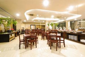 a restaurant with wooden tables and chairs and a bar at Pandanaran Prawirotaman Yogyakarta in Yogyakarta