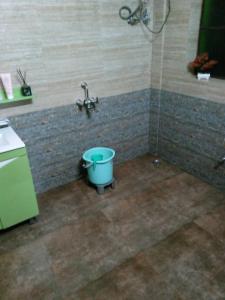 a bathroom with a faucet and a blue bucket at Tenam Garden homestay in Kalimpong